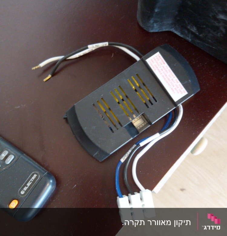 חוטי חשמל מחוברים למכשיר עם מחברים לבנים